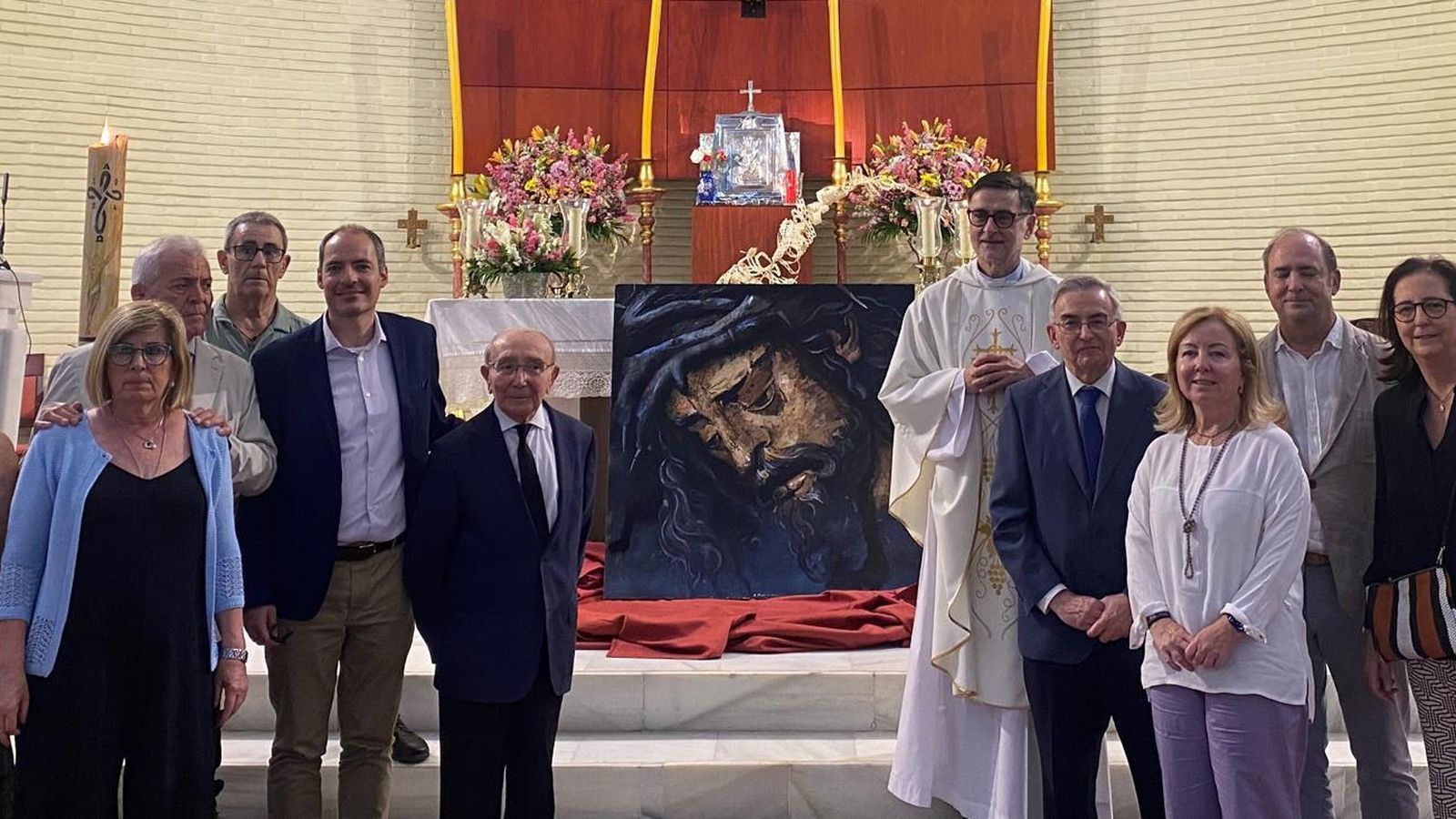 El cuadro donado a la parroquia con los protagonistas de la donación.