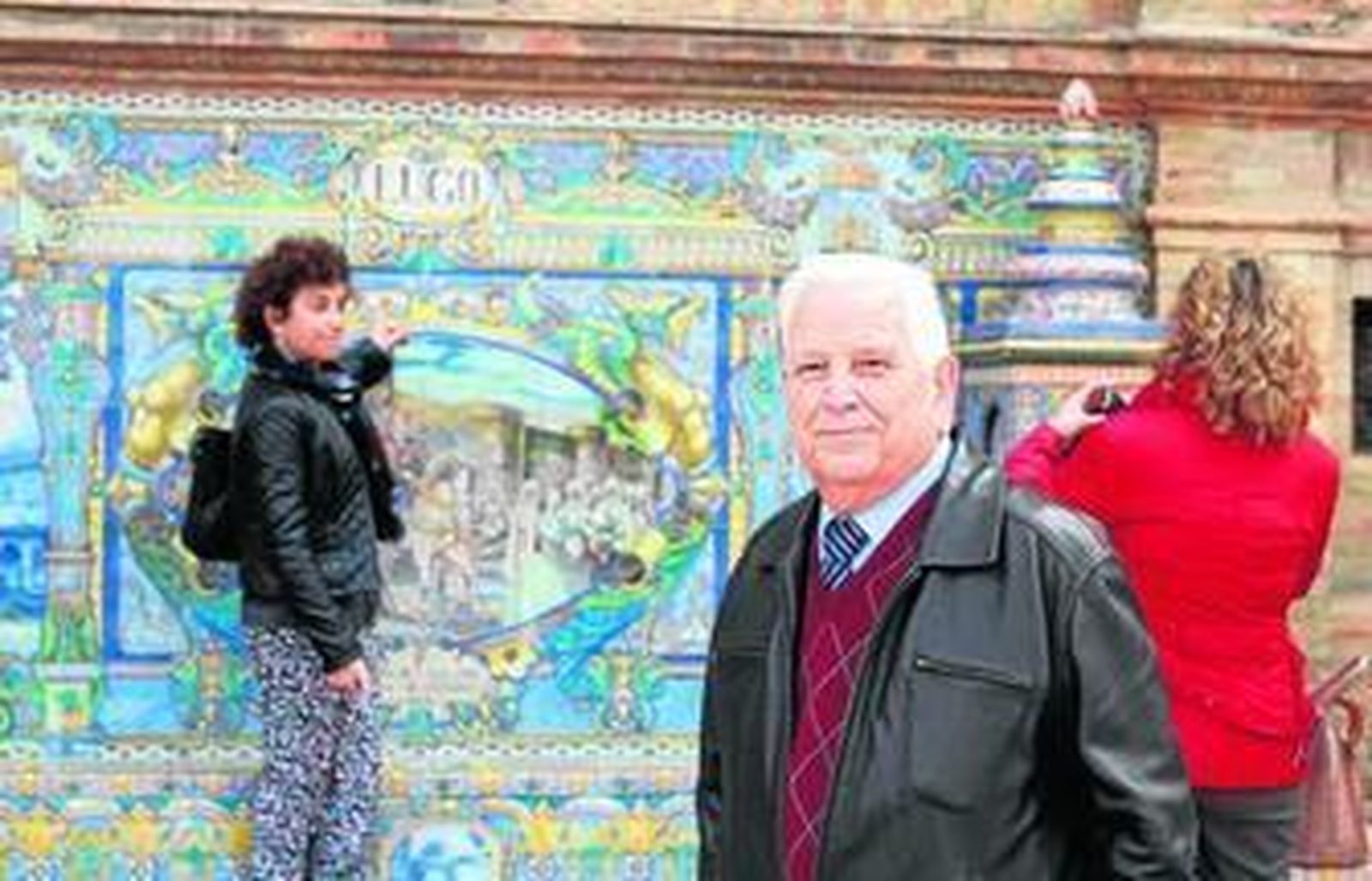 Alfredo Otero, junto al banco de Lugo, donde dos paisanas se hacen una fotografía.