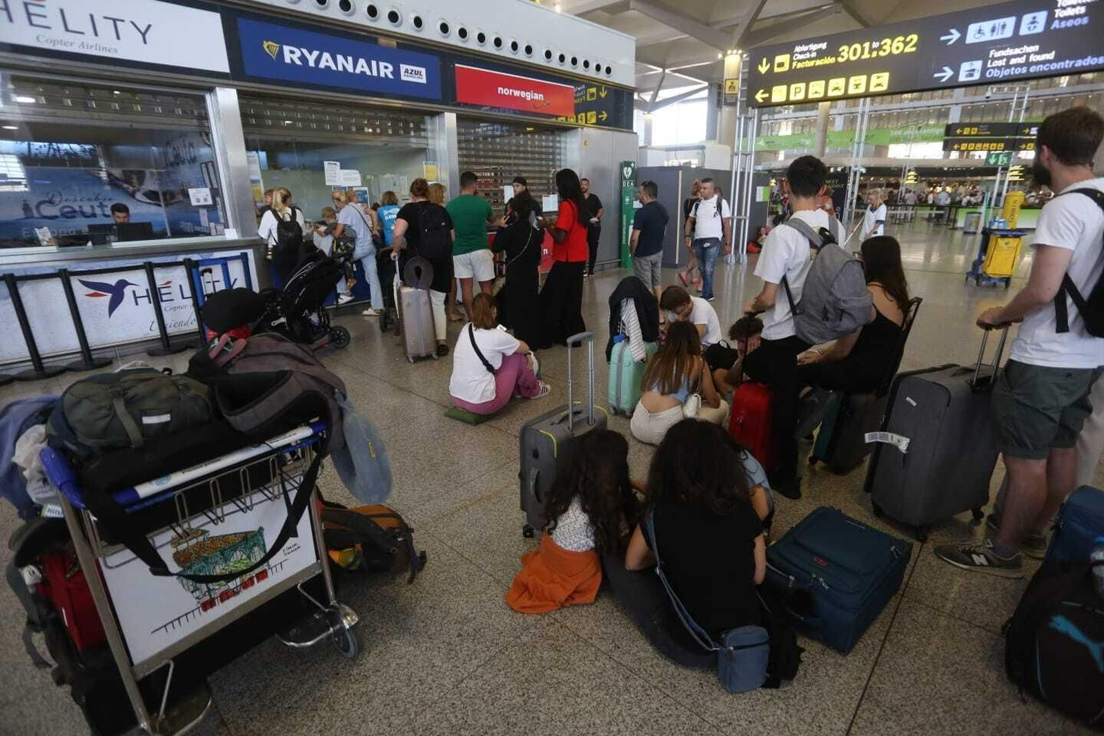 Pasajeros hacen cola para reclamar sus vuelos cancelados en el aeropuerto de Málaga.