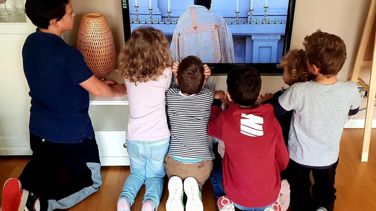 Un grupo de jóvenes almerienses siguen una misa por la televisión estos días.