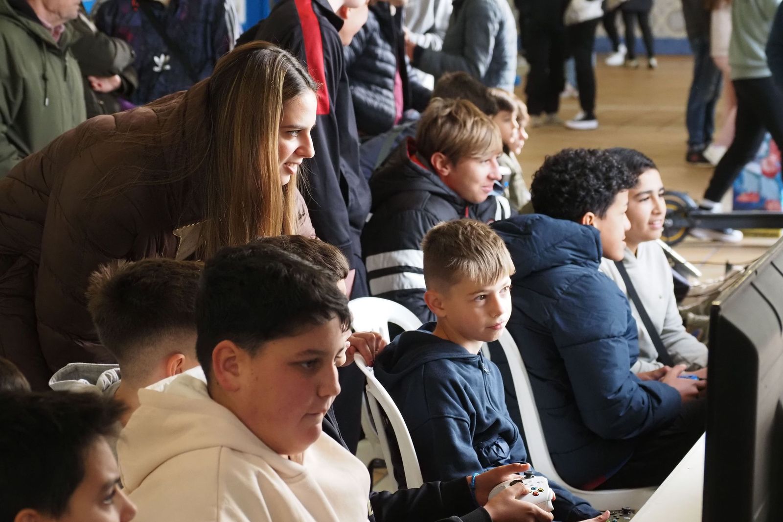 La alcaldesa Milagros Romero con los niños que están probando los videojuegos.