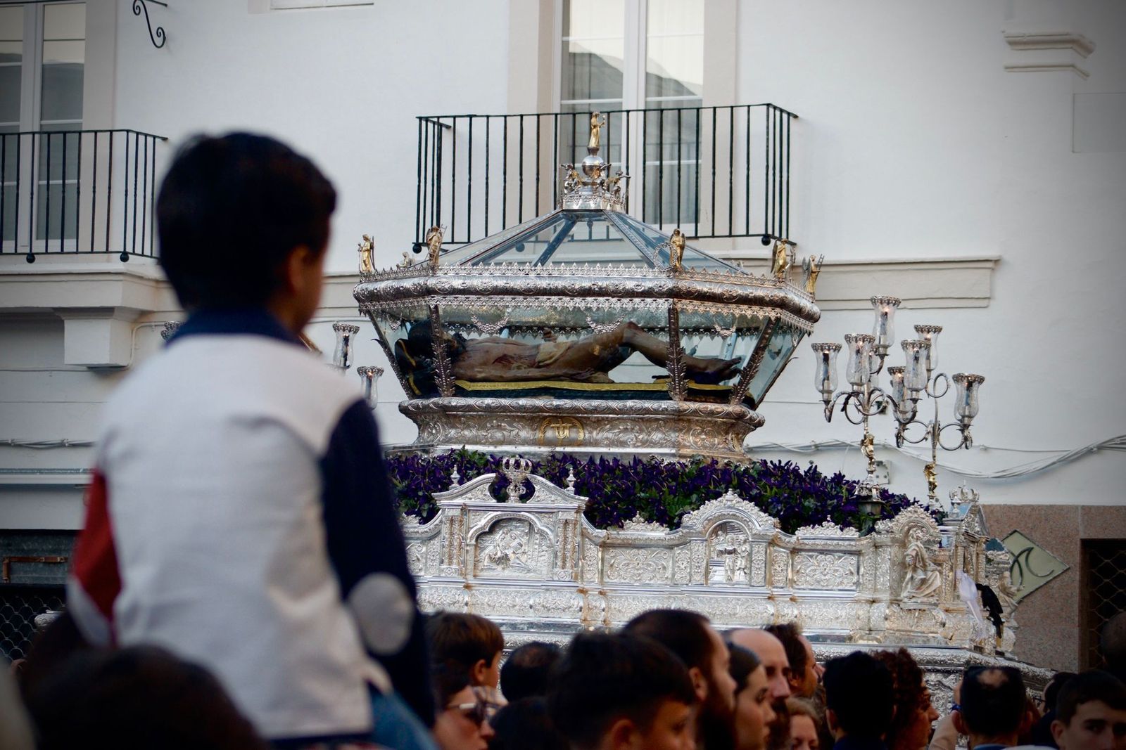 Un niño observa pasar la urna del Santo Entierro.