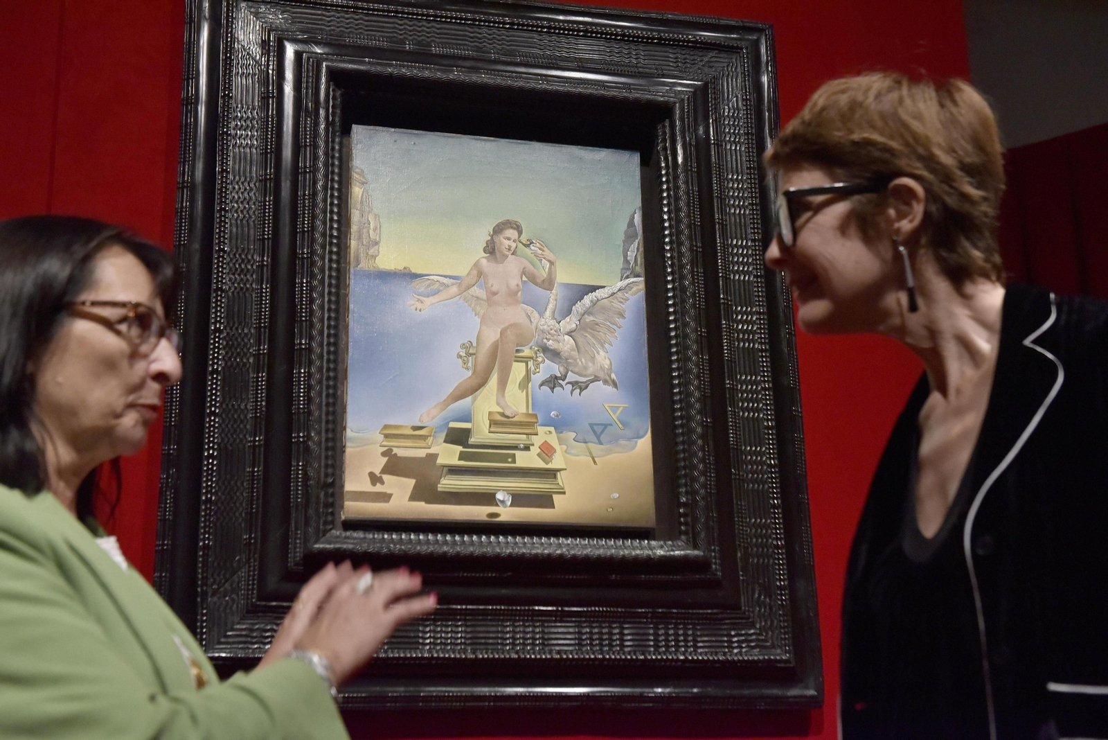 1. Elisa Durán y Montse Aguer, de La Caixa y el Teatro Museo Dalí, ante la obra 'Leda atómica'. 2. Una mujer contempla una proyección sobre el contexto histórico en el que Dalí abrazó el fervor cientifista. 3. 'Triple aparición del rostro de Gala'.  4. Fotografía del artista en Monterrey (California). 5. Gala, en el apartado dedicado a su figura. 6. Un hombre camina por el "ámbito" dedicado a la física atómica.