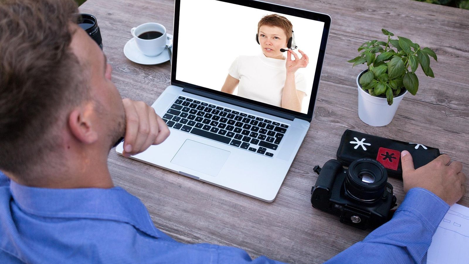 Un joven atienda la lección de una profesora on line a través de una webinar Un joven atienda la lección de una profesora on line a través de una webinar