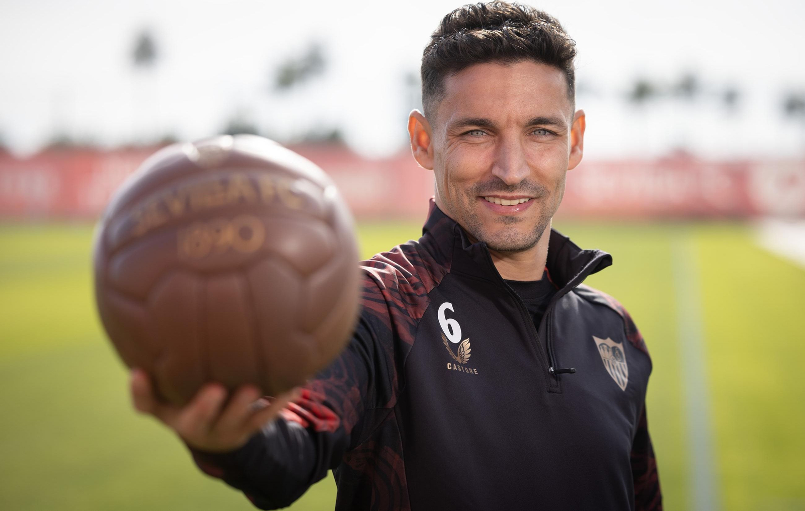 Jesús Navas enseña un balón 'vintage' en la ciudad deportiva del Sevilla.