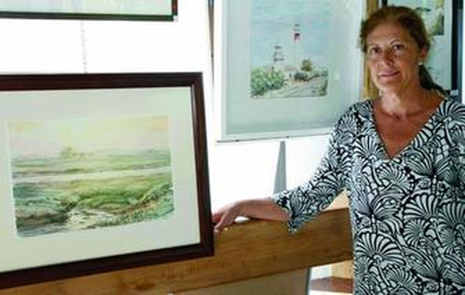 Caridad Orta junto a algunas de sus acuarelas.