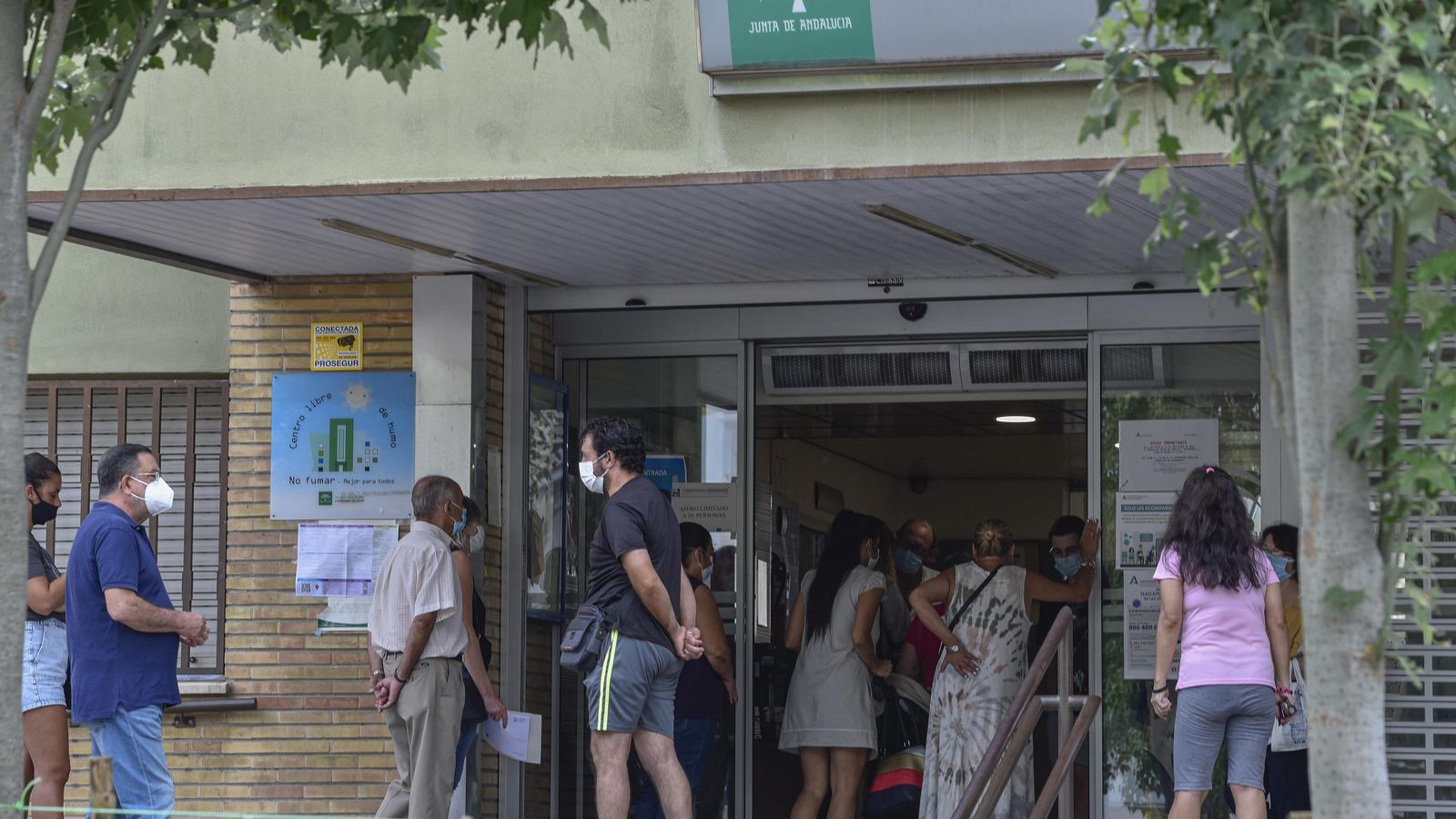Varias personas hacen cola para poder acceder al interior del centro de salud de El Greco.