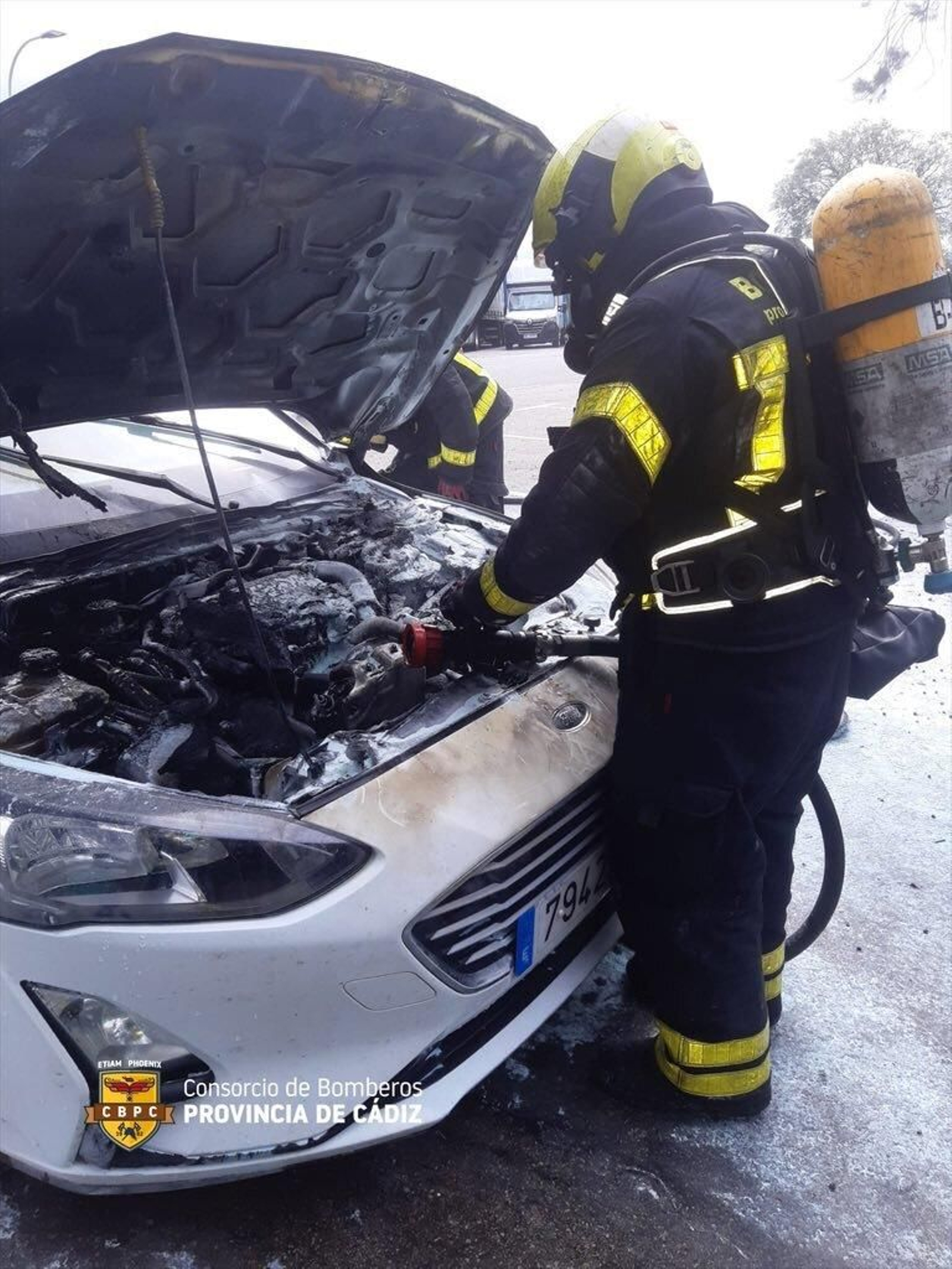 Un bombero, comprobando la extinción del incendio del coche.