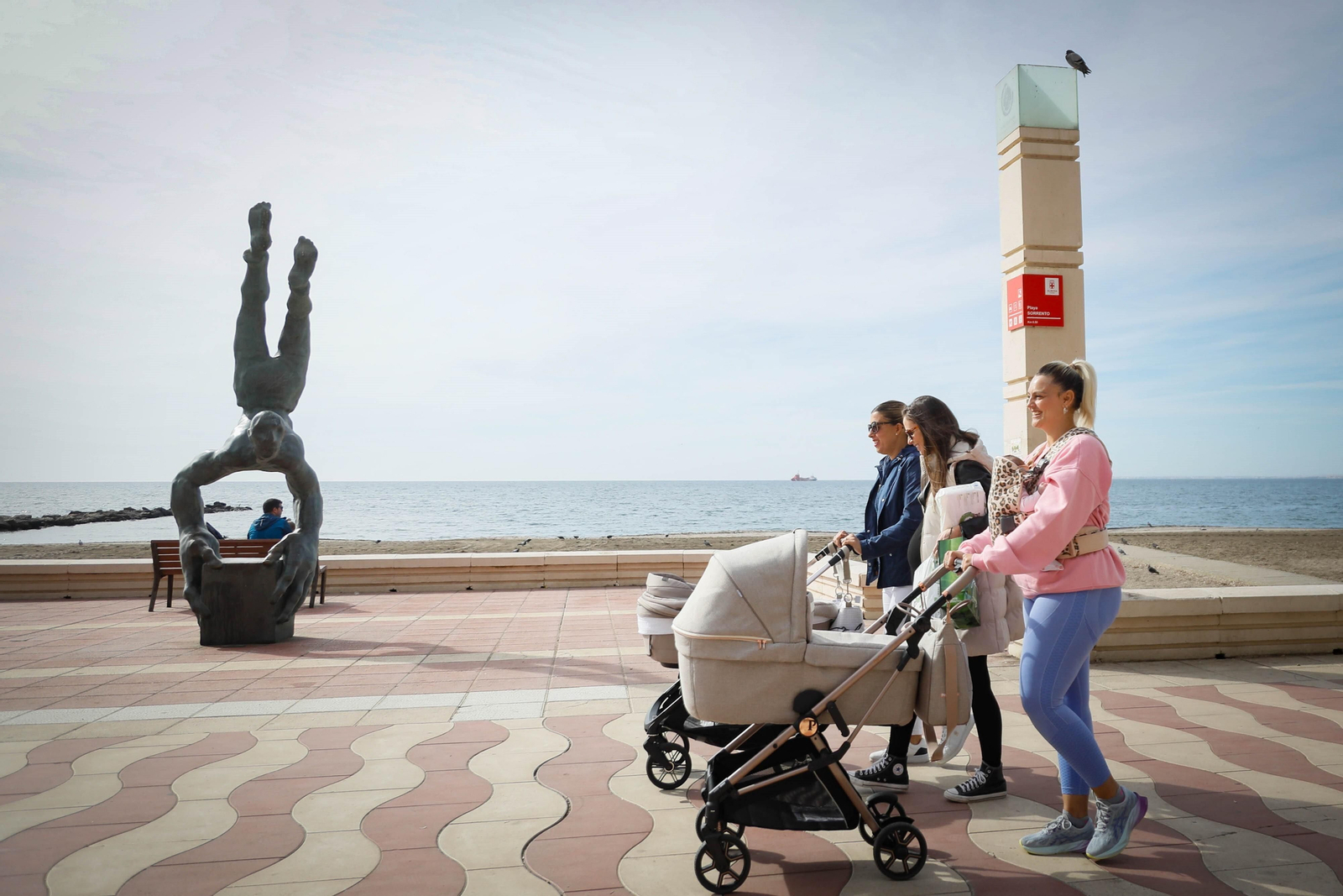Varias madres pasean por el Paseo Marítimo de la ciudad con sus pequeños y pequeñas en el carrito.