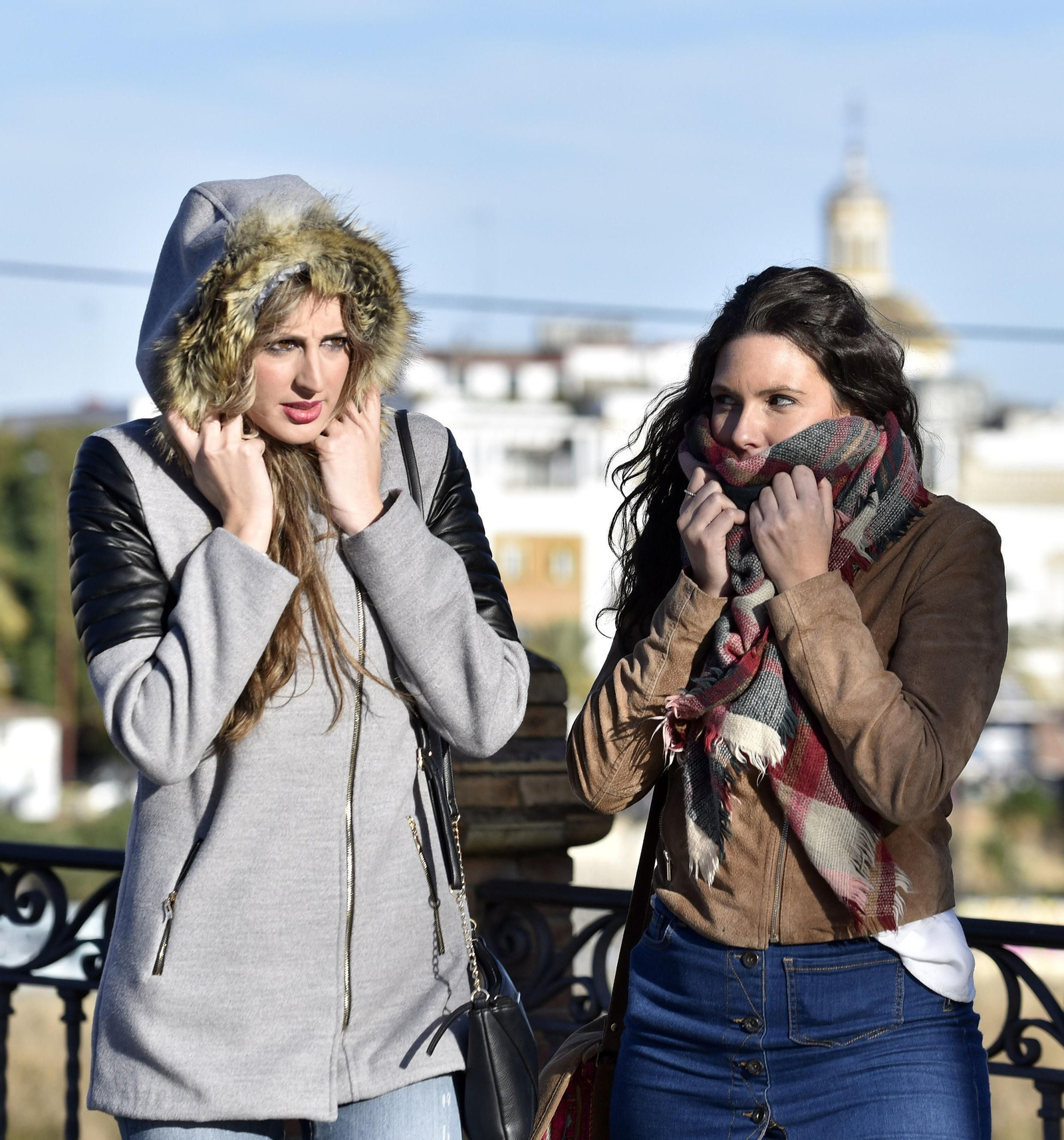 Dos jóvenes se resguardan del frío en Sevilla.