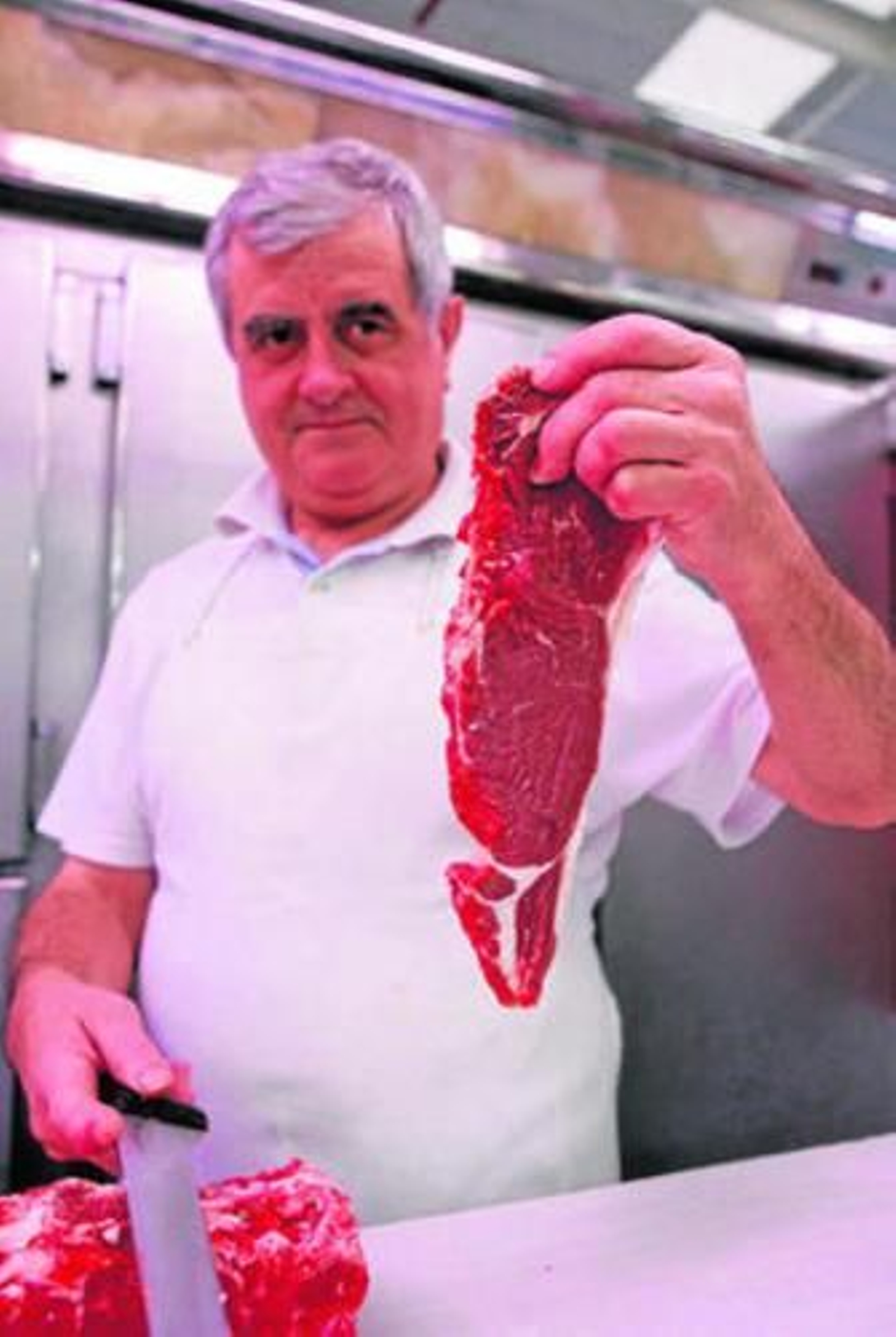 Rafael López posa junto a un chuletón de su carnicería.