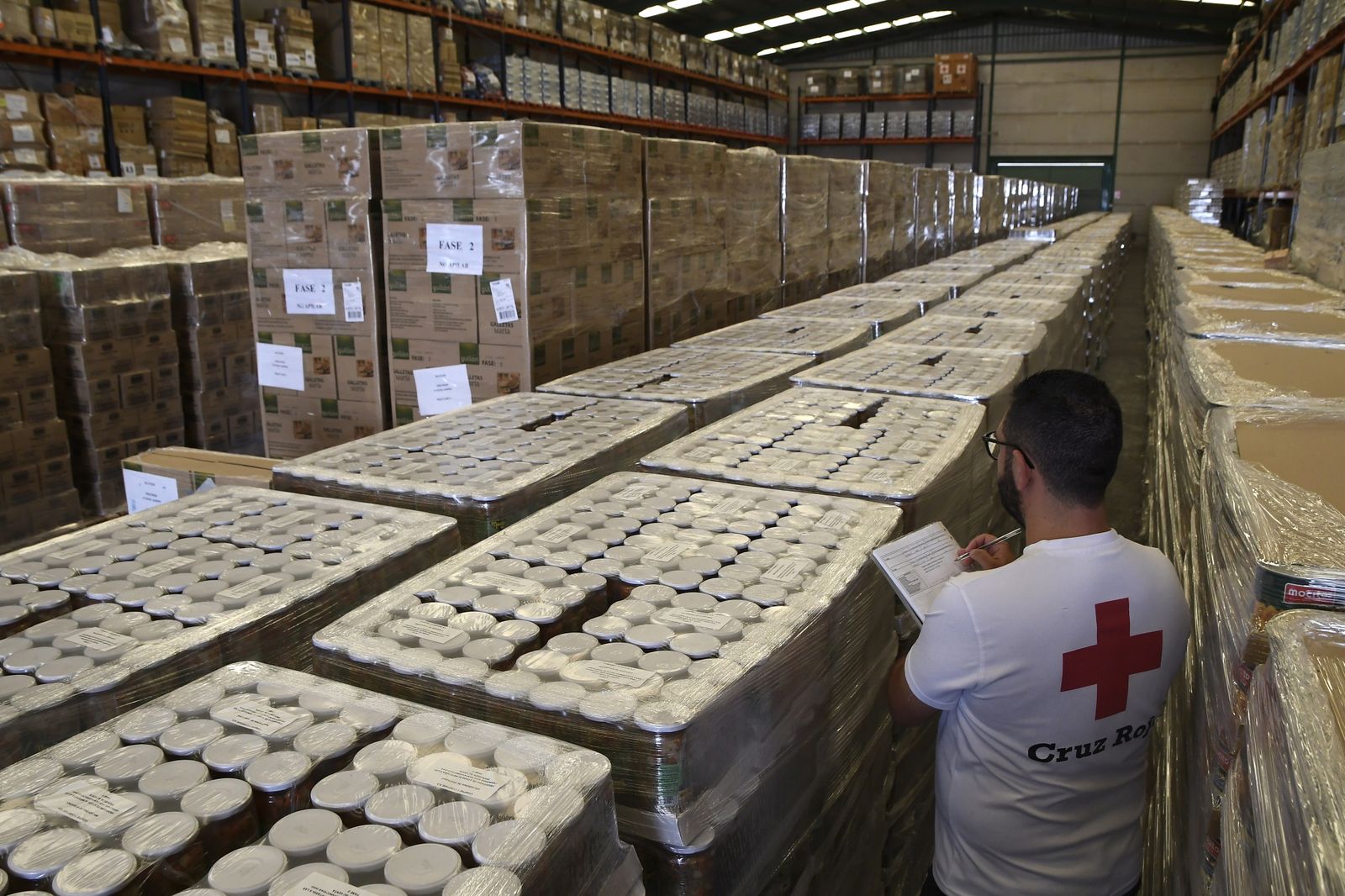 Un técnico trabajan en el centro logístico de Cruz Roja en Almería que almacena 750.000 kilos de alimentos del Plan de Ayuda Alimentaria destinado a personas desfavorecidas.