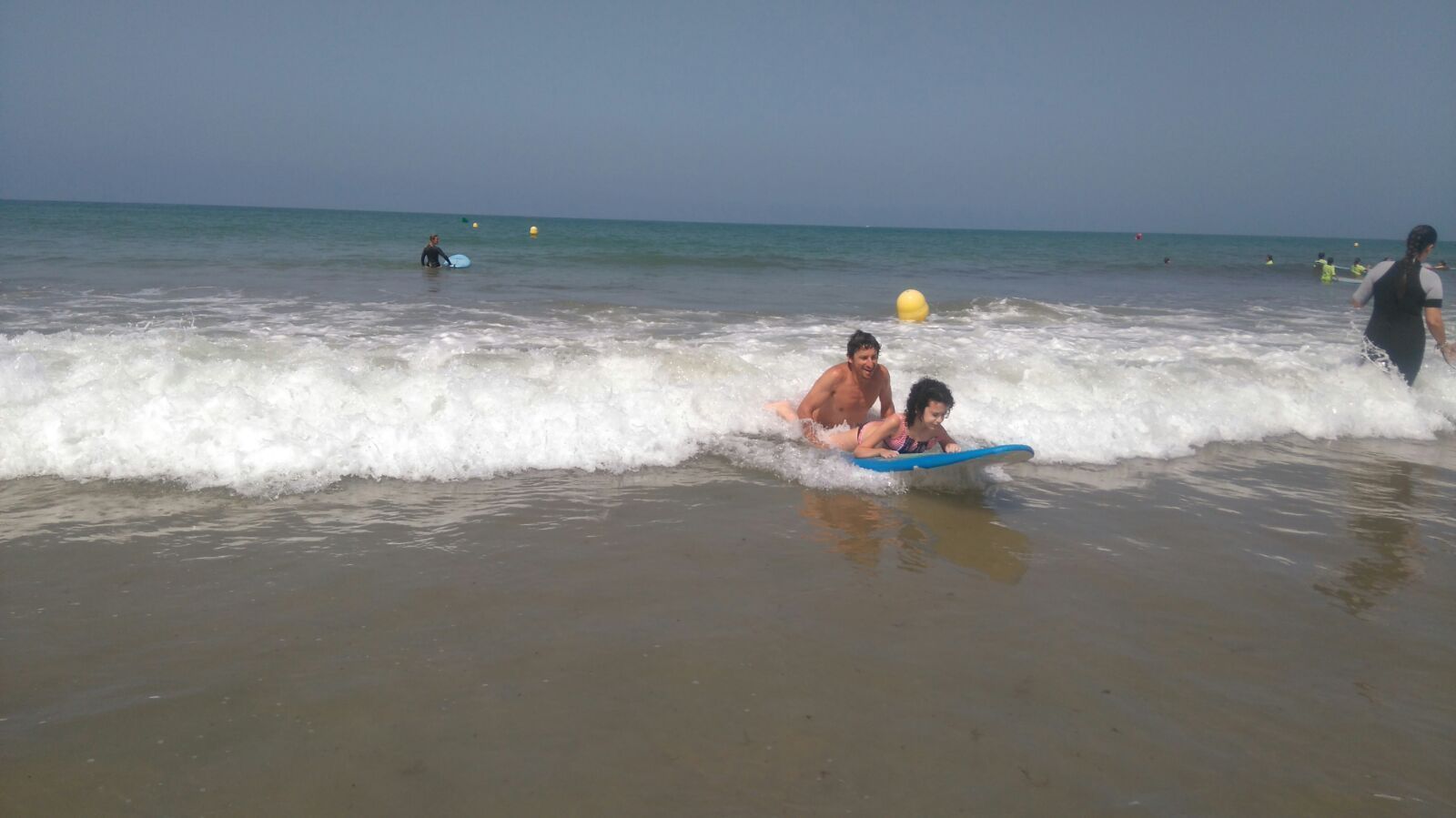 Paula con uno de los monitores de la escuela de surf Offshore en su primera toma de contacto con este deporte.