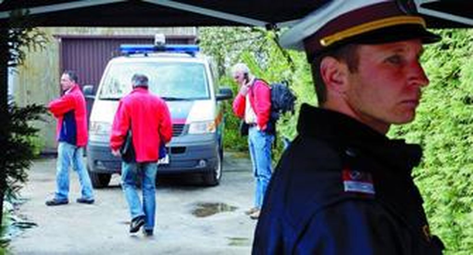 En primer término, un policía custodia el acceso a la casa de los horrores de Amstetten.