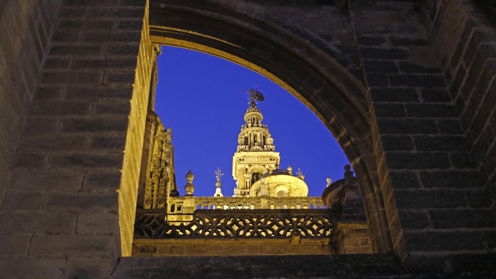 La Giralda se asoma entre arcos de piedra.