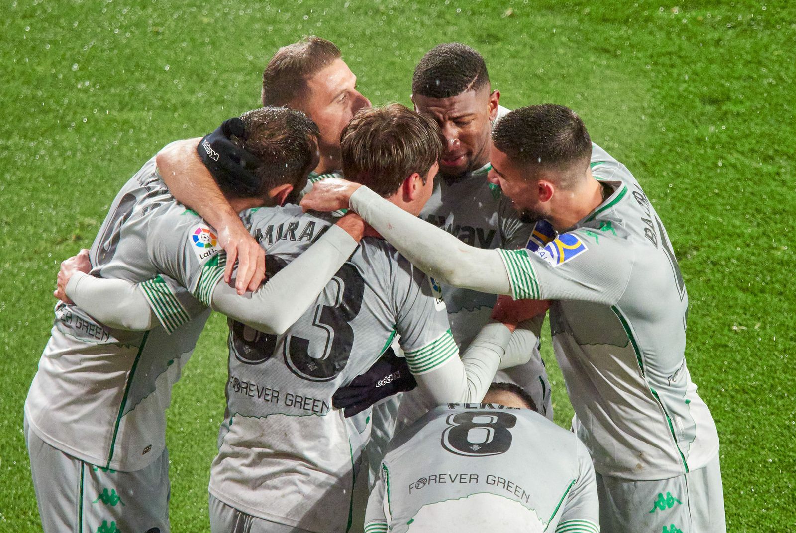 Los jugadores del Betis celebran el 2-0 bajo la lluvia helada.