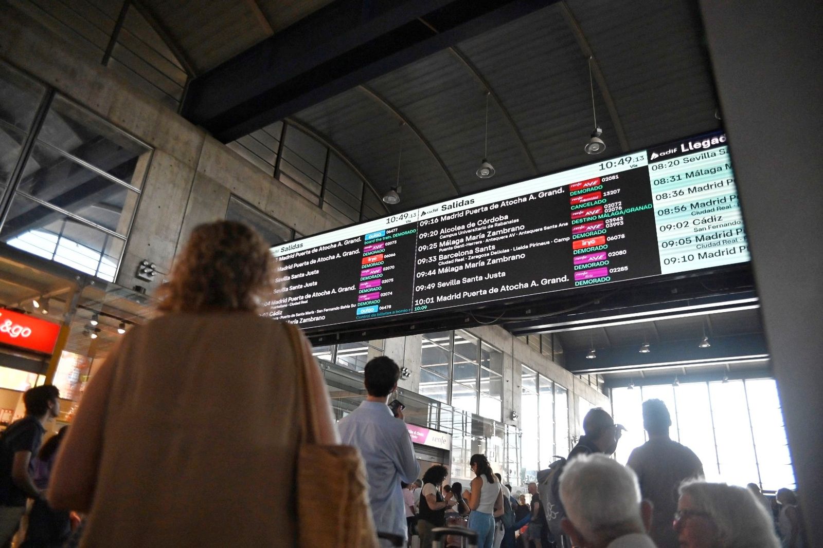 Imagen de archivo de varias personas mirando el panel de llegadas y salidas de trenes de la estación.