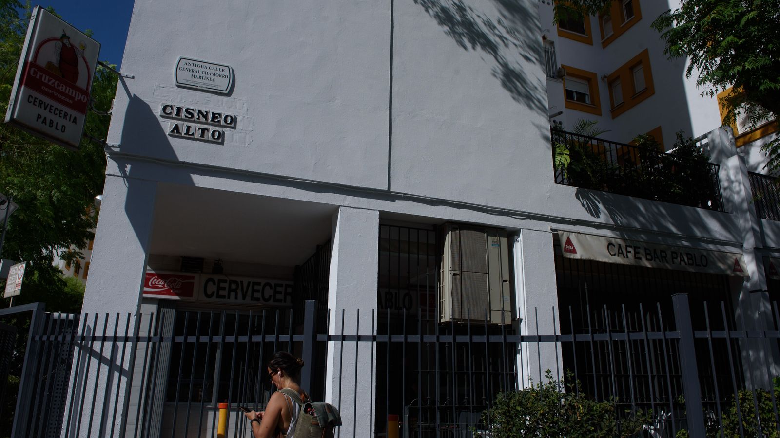 Una mujer mira el móvil junto al rótulo de Cisneo Alto.