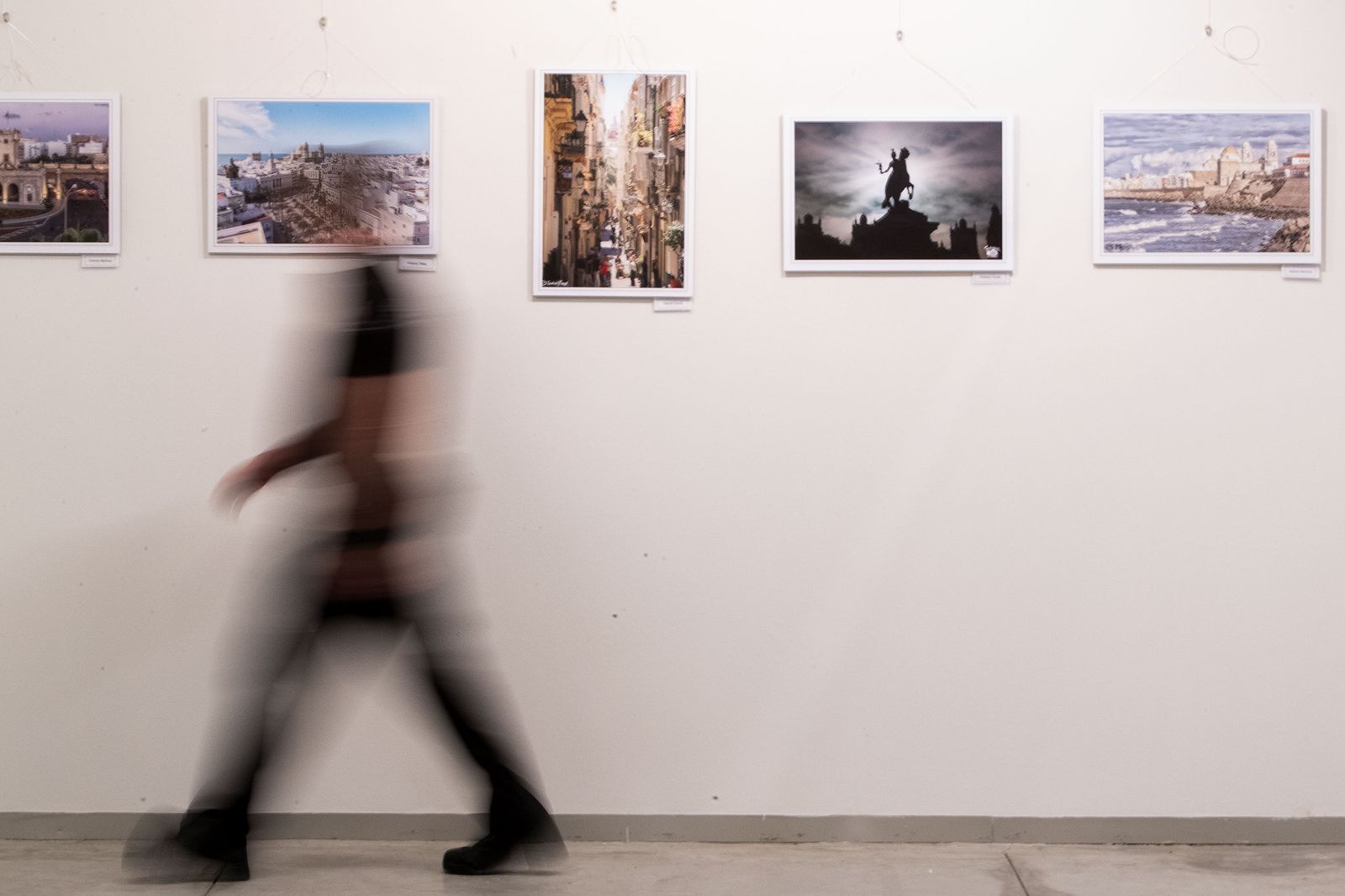Un persona pasa ante algunas de las fotografías de la exposición de Blanco y Negro.