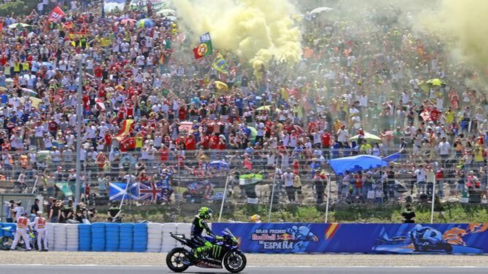 Rossi, saludando a la 'pelousse' con Álex Rins subiéndose a la valla para celebrar con los aficionados.