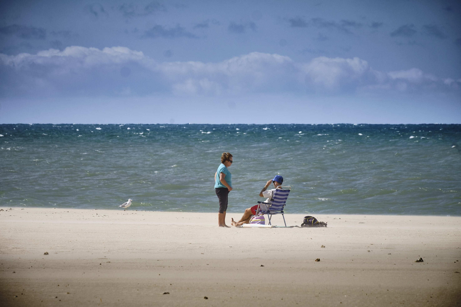 Una pareja en la playa, en un día de levante.