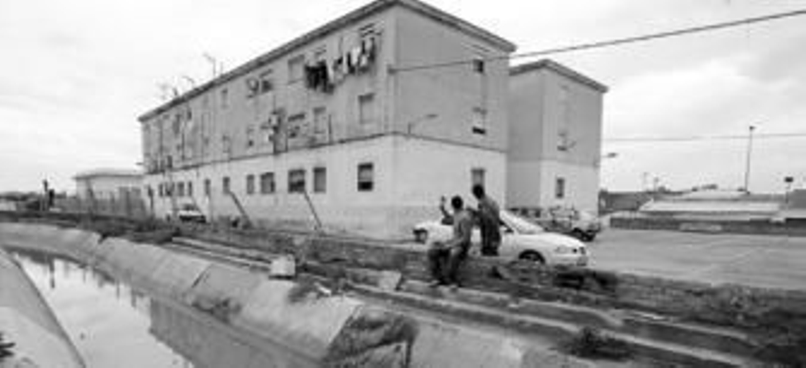 Dos vecinos de El Portal junto al canal mirando a las viviendas afectadas.