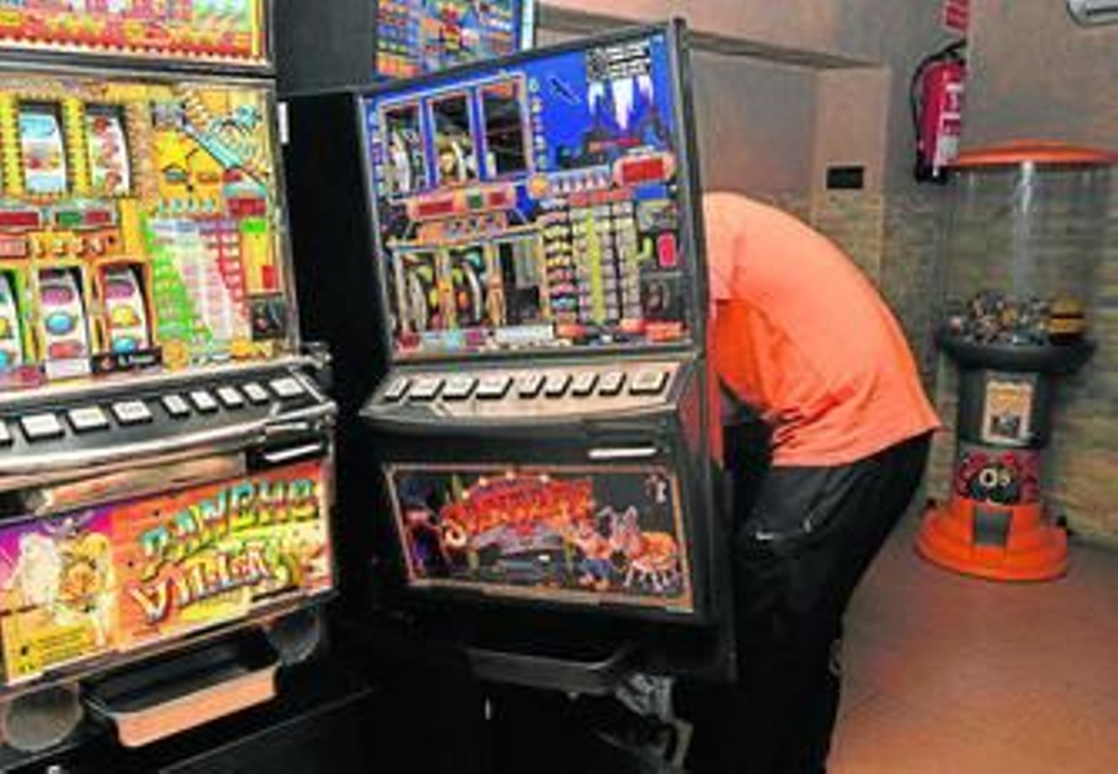 Un técnico observa los daños de la tragaperras reventada en el bar 'El Gallego'.