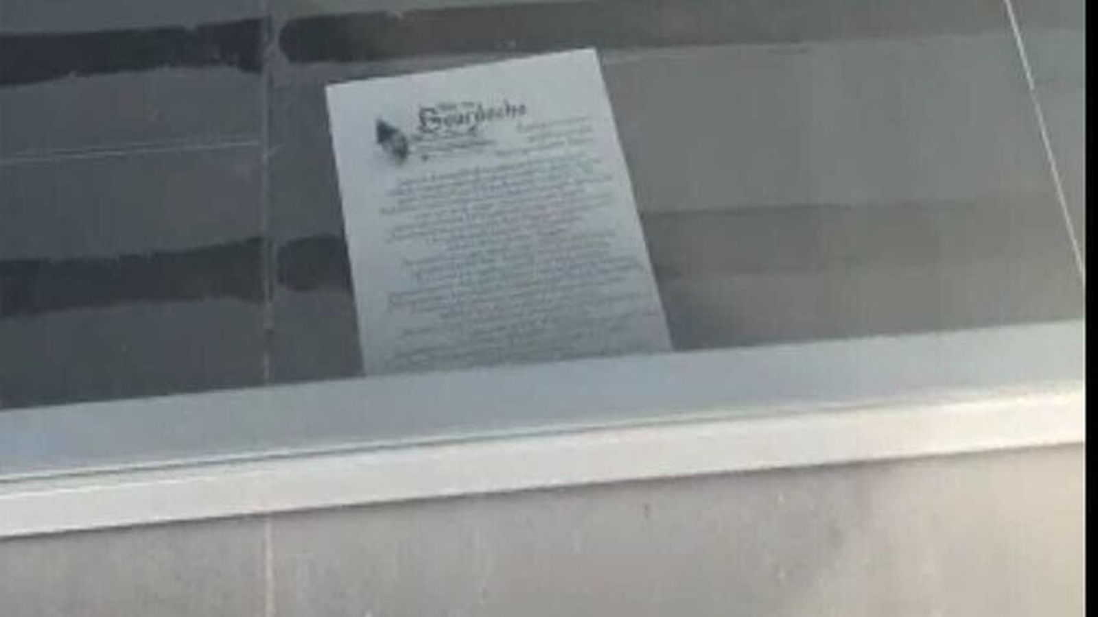 La irónica octavilla, por debajo de la puerta de un comercio.