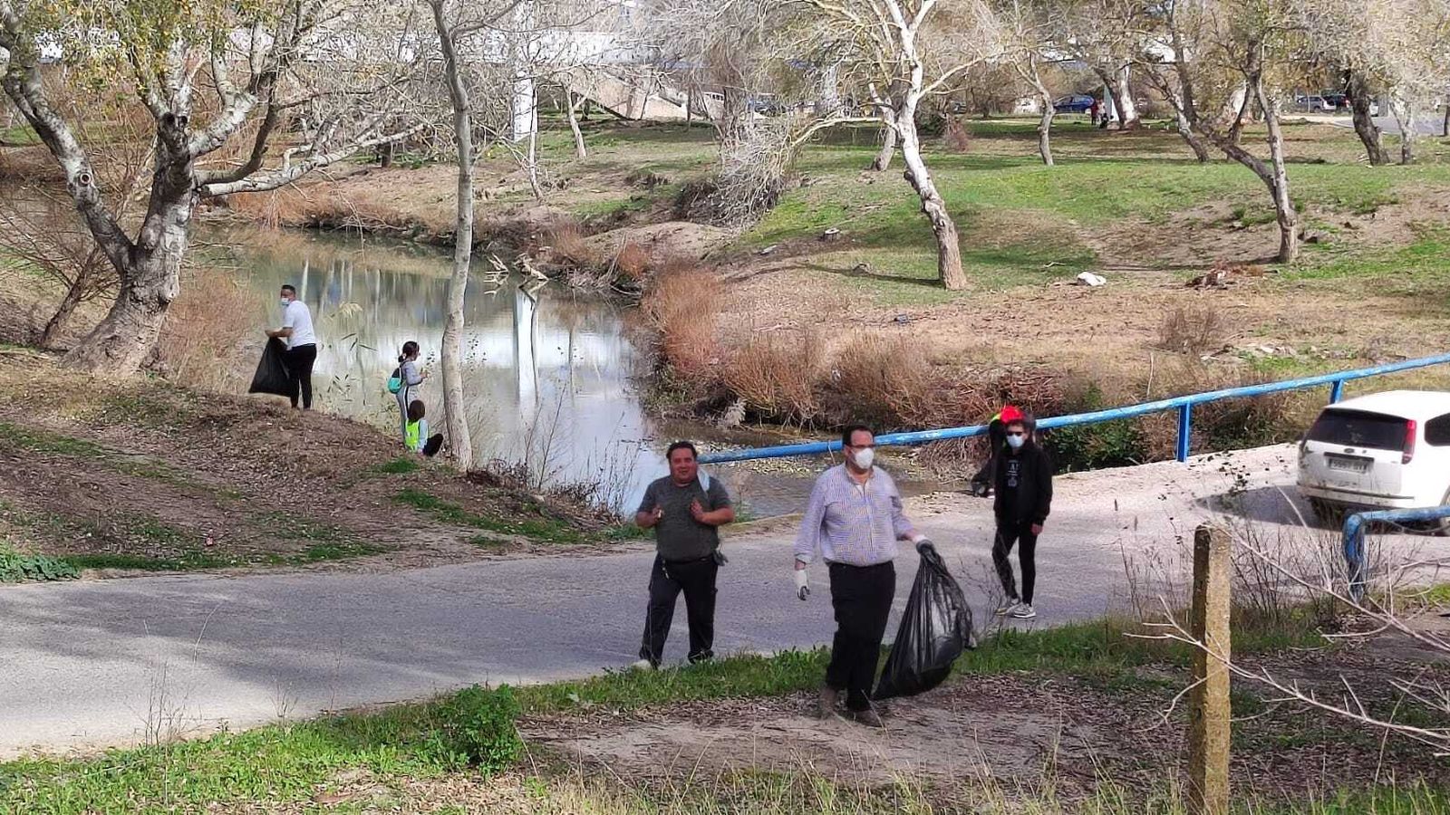 Algunos voluntarios durante la recogida de basuras junto al río.