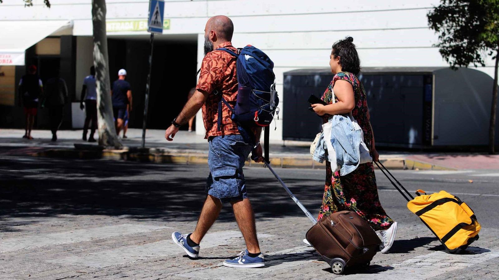 Turistas se mueven por la ciudad con sus maletas