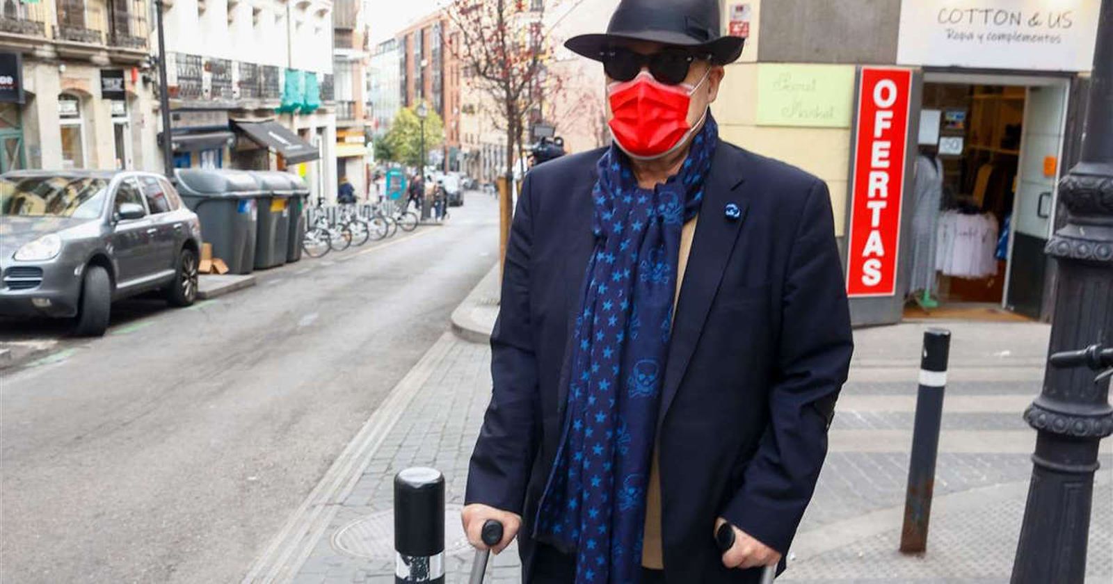 Antonio Resines, caminando con ayuda de dos muletas, en la puerta de su casa en Madrid.