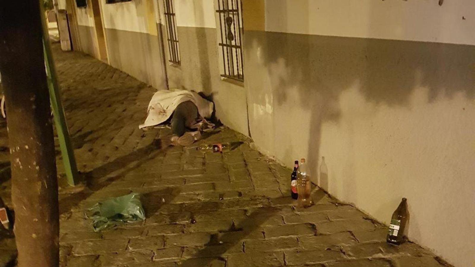 Restos de suciedad y una persona sin hogar en el suelo.