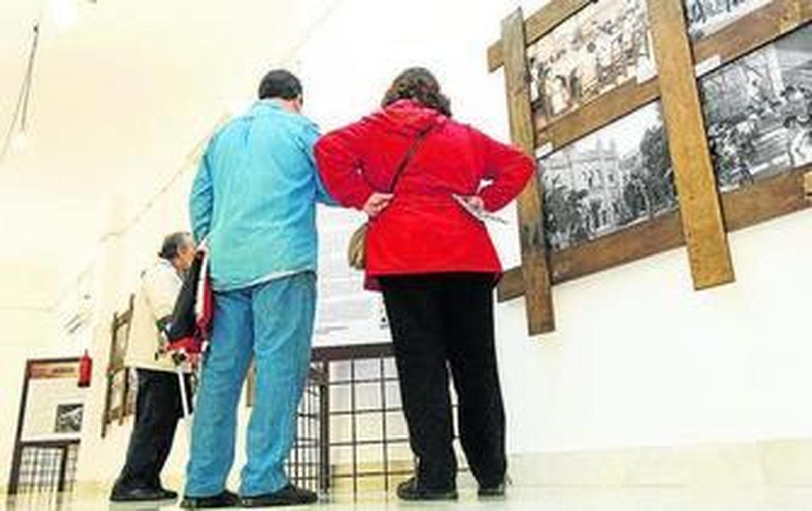 Visitantes de la muestra observan los paneles informativos.