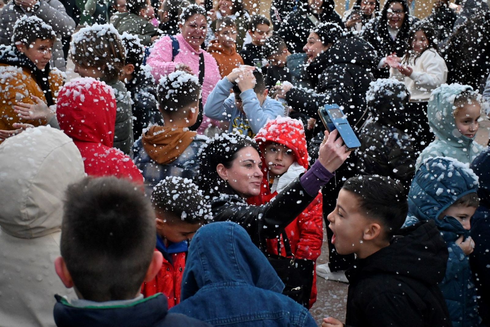 Personas disfrutando de la anterios nevada en la Plaza de los Descubridores.