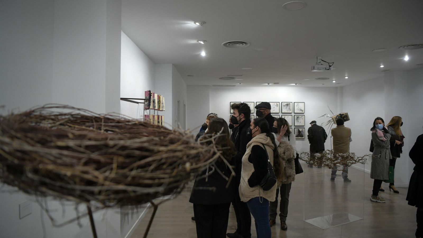 Varias personas visitan la exposición de Portero