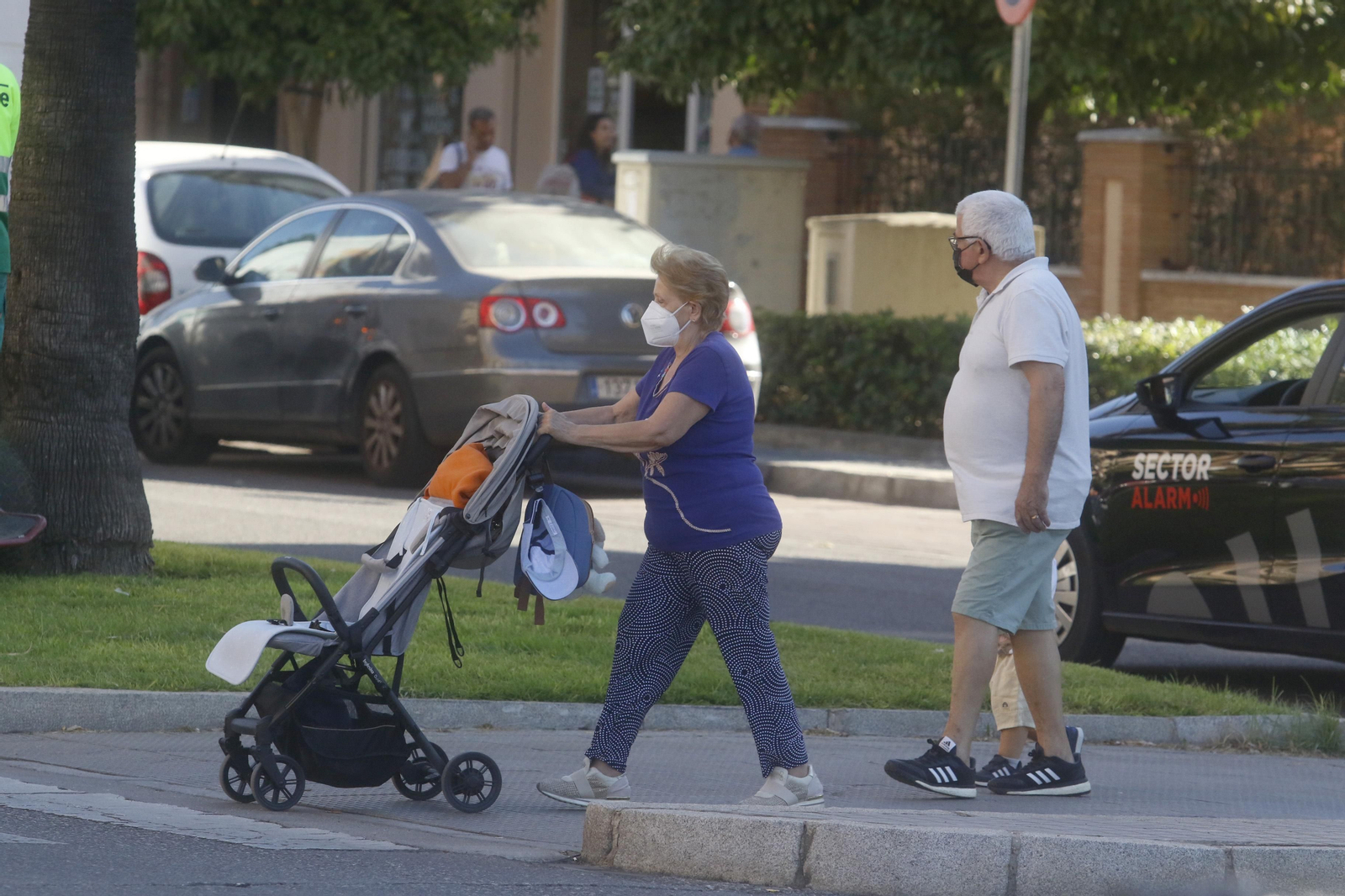 Una mujer y un hombre, acompañados de un niño, se disponen a cruzar una calle.