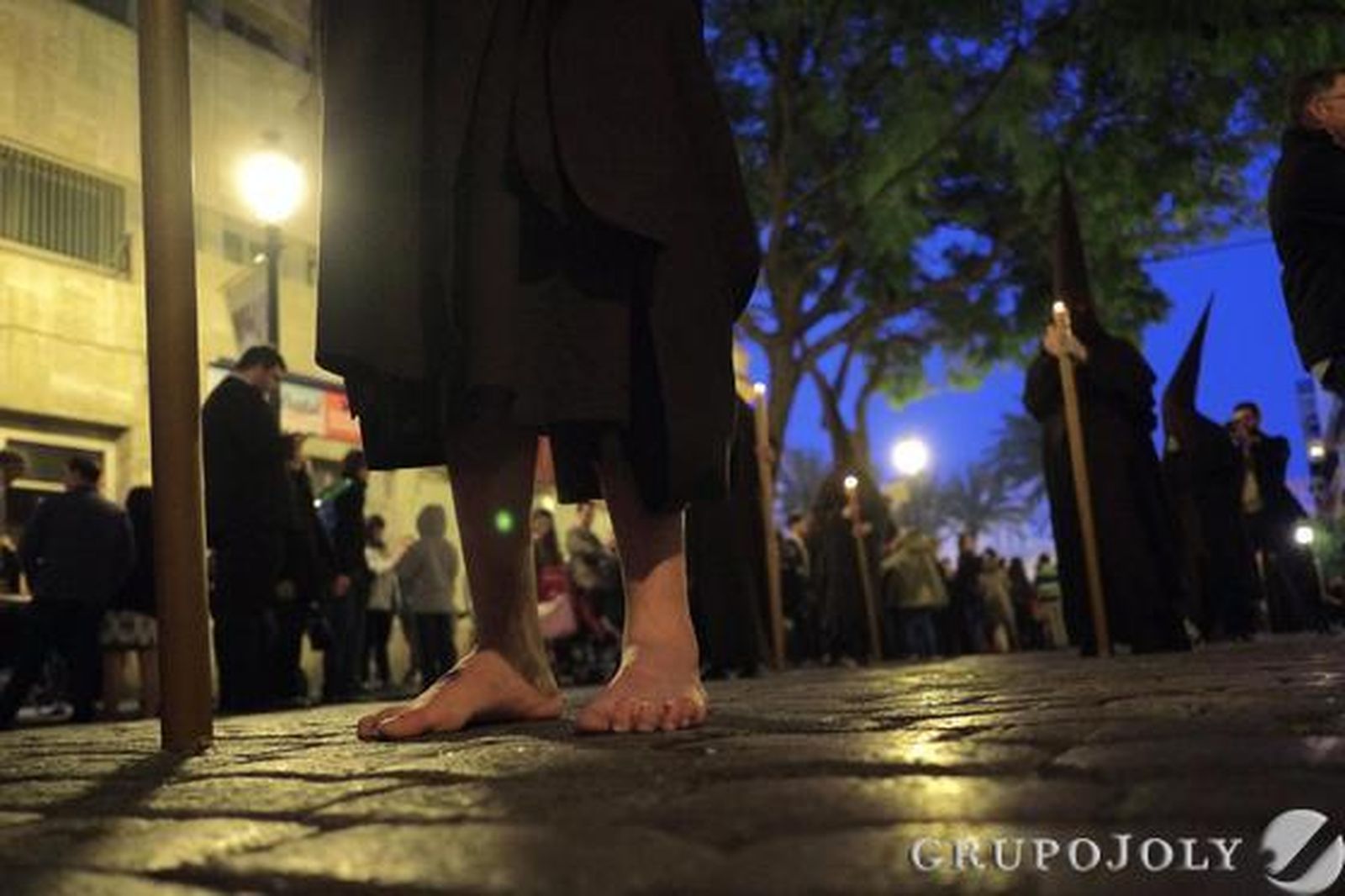 Un nazareno descalzo de La Lanzada en una parada de la cofradía en Porvera.

Foto: Manu Garcia