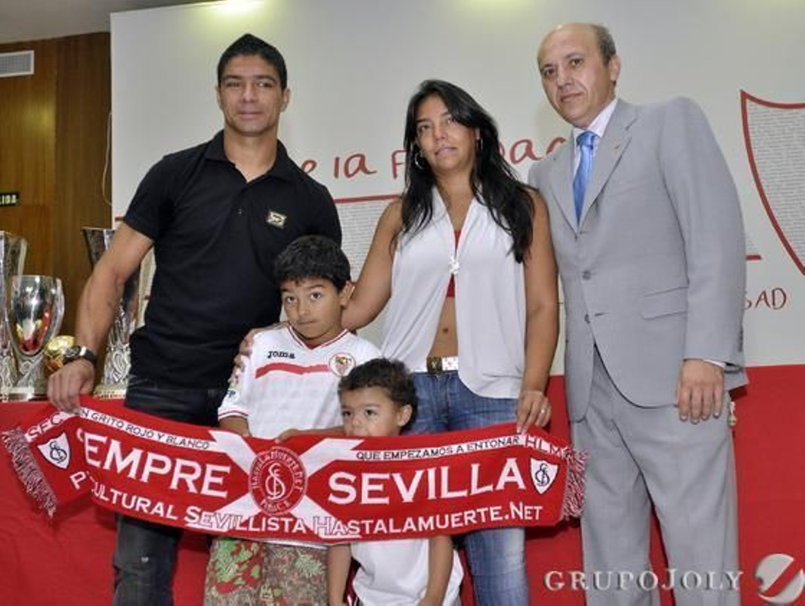 La familia de Renato posa, junto a José María del Nido, con una bufanda del Sevilla.

Foto: Manuel Gómez
