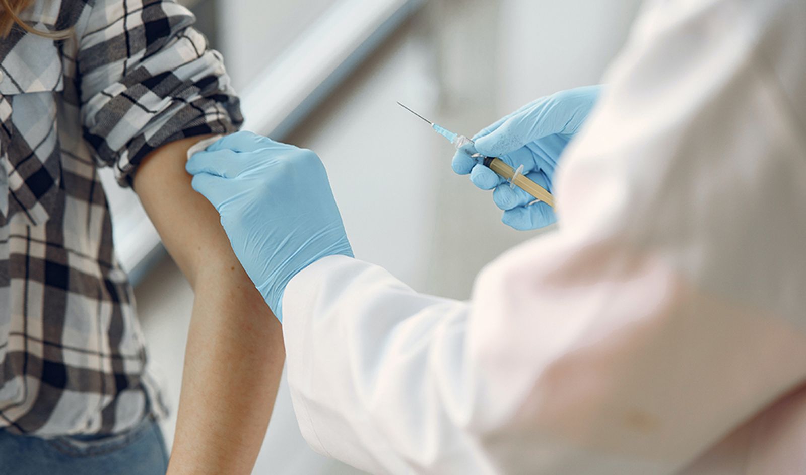 Un sanitario pone una vacuna a un paciente.