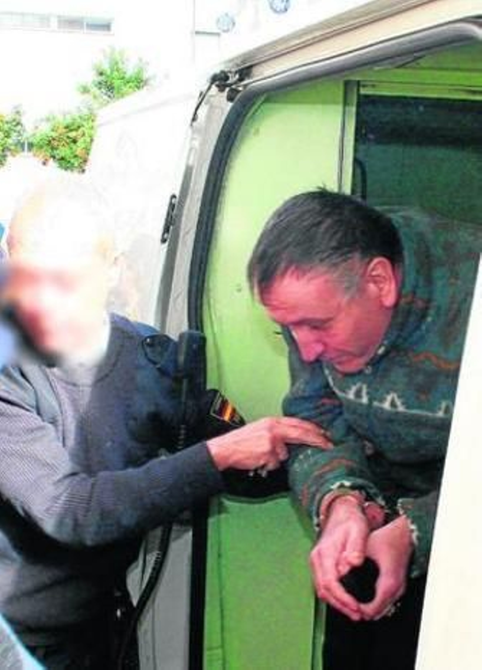 Un policía coge por el brazo al pederasta a su llegada al Palacio de Justicia el pasado lunes.