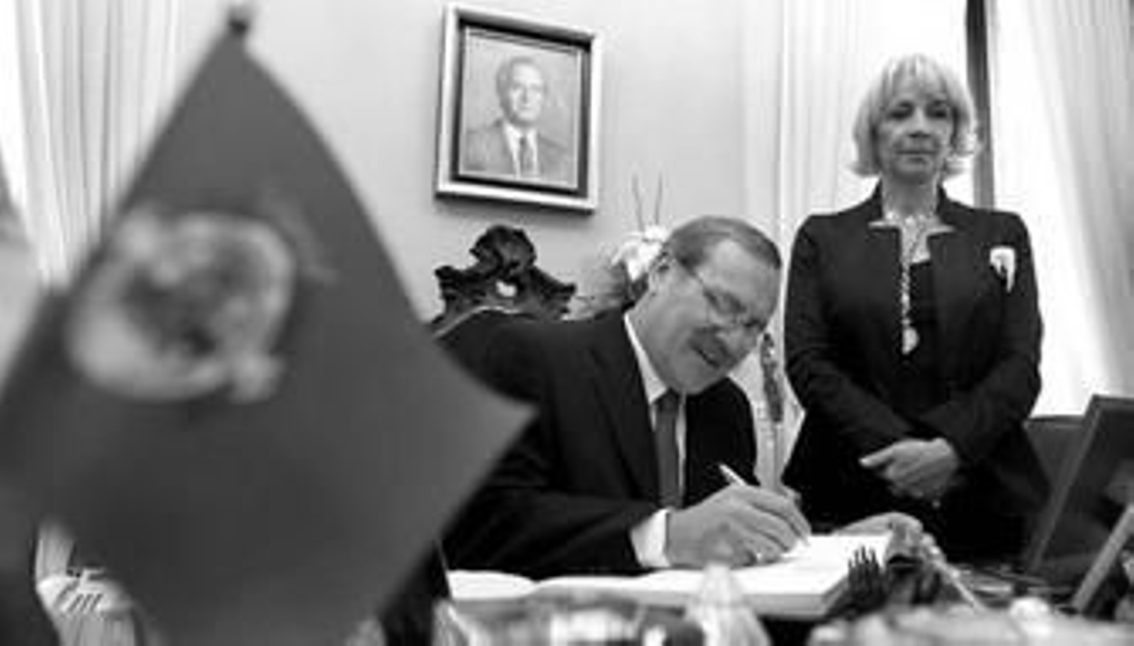 Ricardo Elhrich firma en el despacho de Alcaldía en el libro de honor de la ciudad ante la mirada de Teófila Martínez.