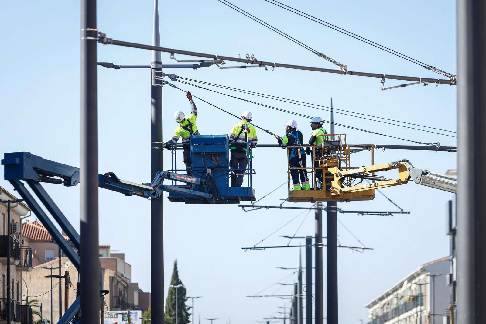 Empleados instalando los cables en la catenaria