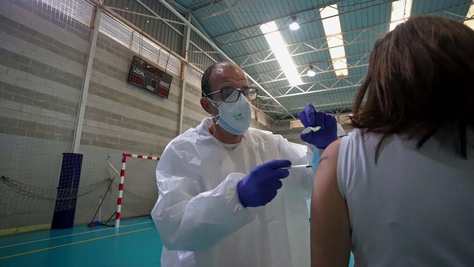 Un enfermero administra una vacuna a una mujer en Algeciras.