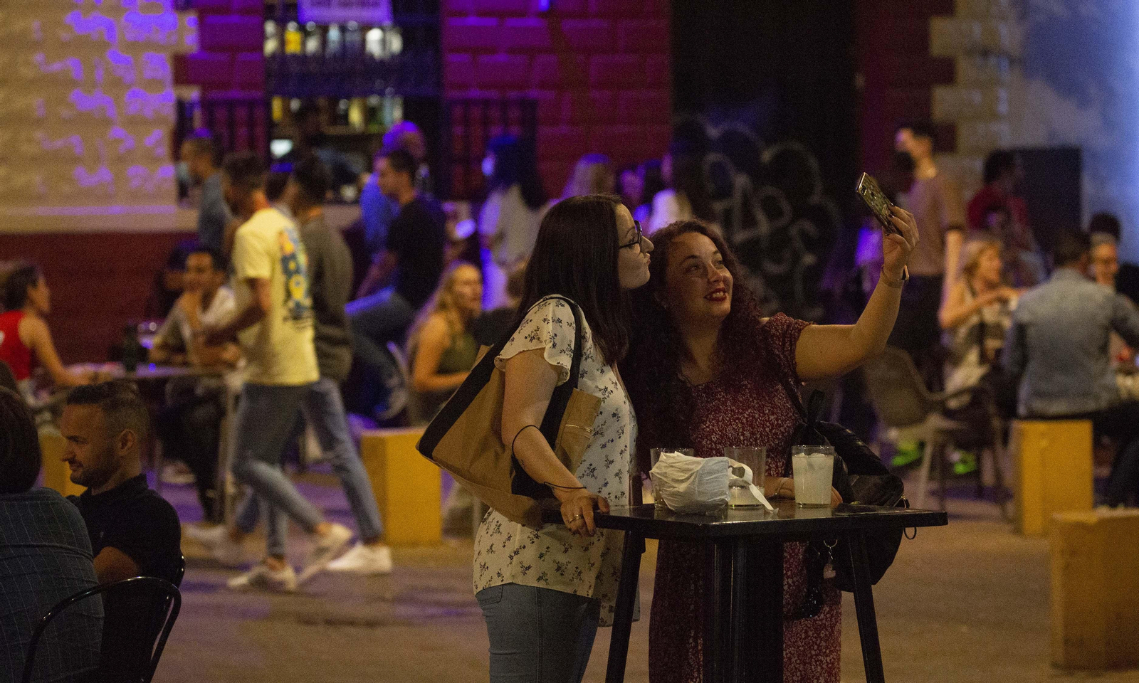 Varias personas disfrutan de la noche del sábado en Sevilla tras el fin del estado de alarma.