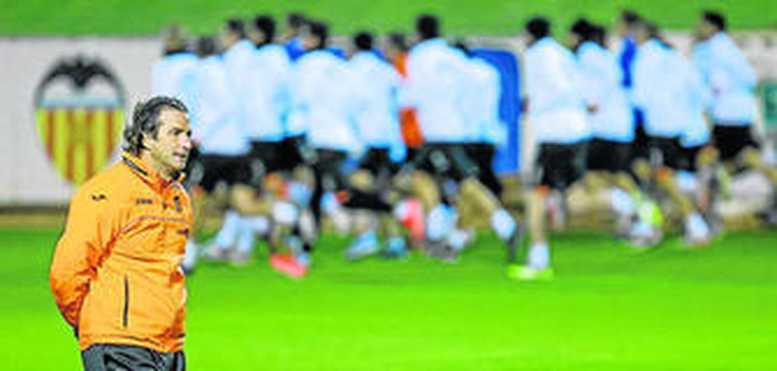 Juan Antonio Pizzi, entrenador del Valencia, con su plantilla al fondo durante un entrenamiento.