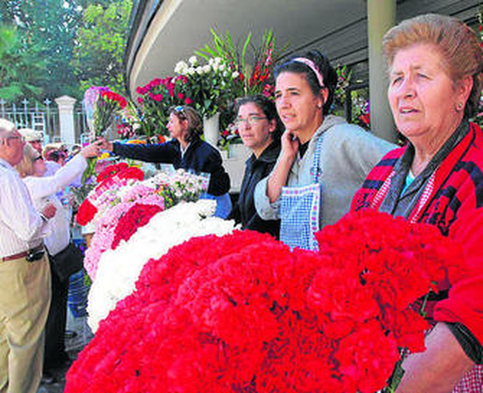 1, 2 y 5. Los granadinos acudieron ayer al cementerio de San José para adecentar las tumbas, nichos y columbarios y recordar a sus difuntos con flores. 3. Las dependientas de la Floristería Araceli vendieron la mitad de flores que el año pasado. 4. Durante la mañana, el servicio de escaleras ofreció un centenar de servicios menos que durante el pasado año 2008. Reportaje Gráfico: Pepe Torres / Patri Díez.