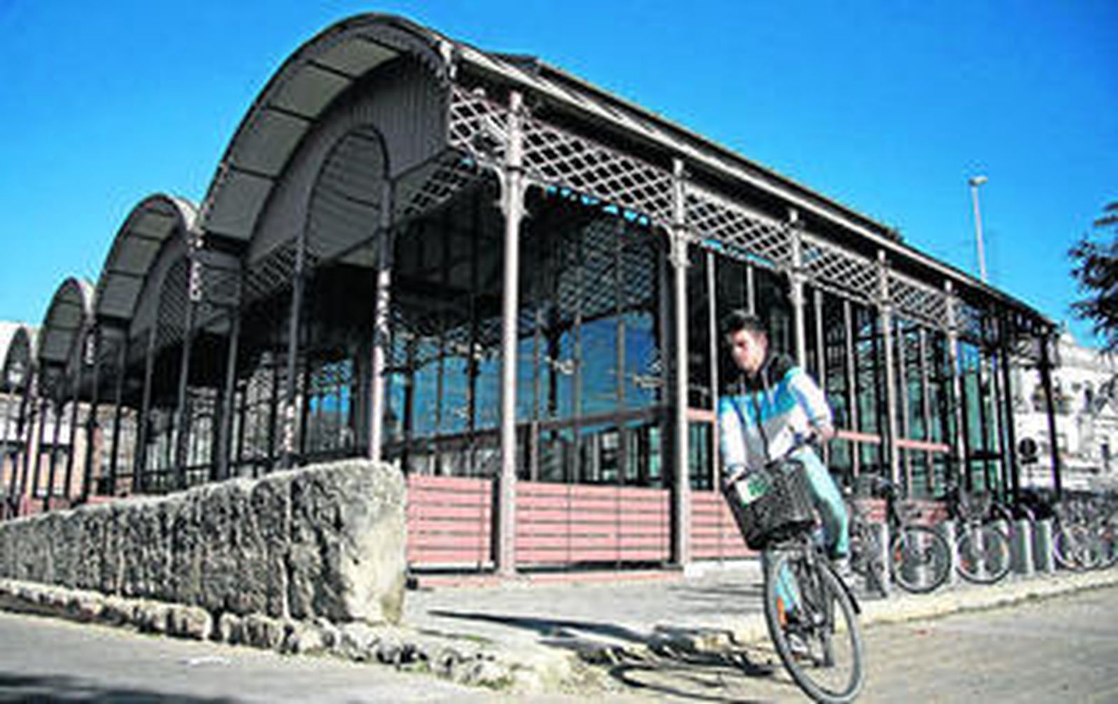 Un cliclista junto a la nave del Barranco, situada a la vera del Guadalquivir y junto al Puente de Triana.