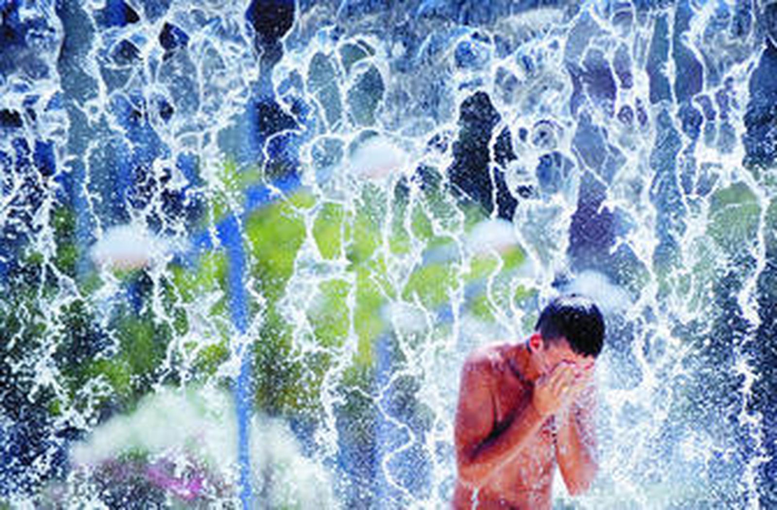 Un joven se refresca en una fuente durante la ola de calor del pasado verano en Córdoba.