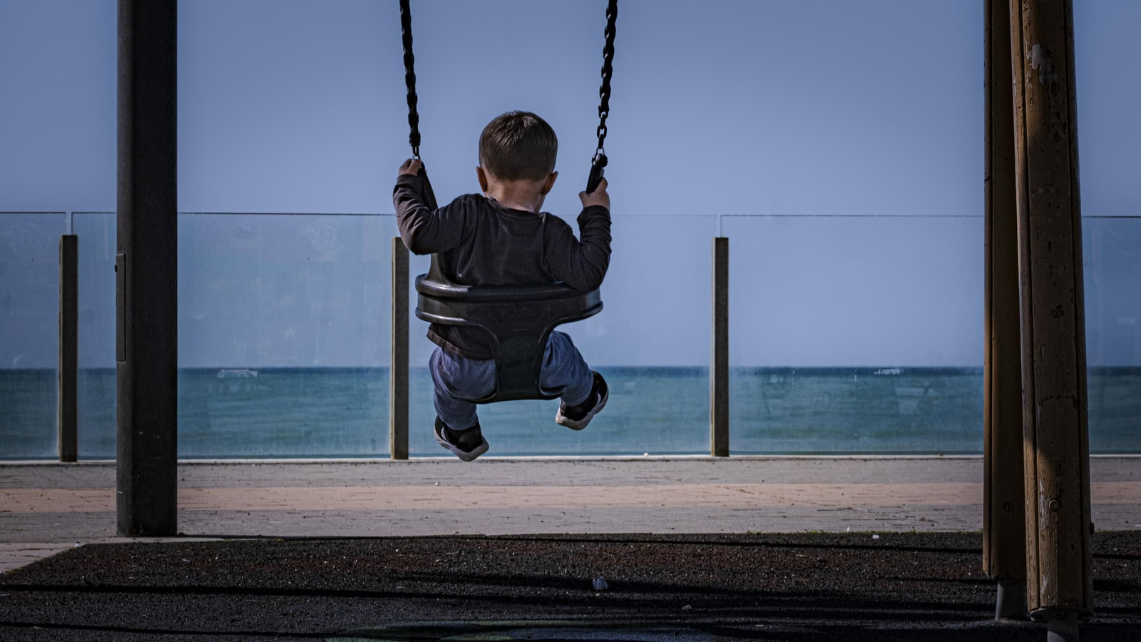 Un pequeño, en un columpio en el Paseo Marítimo.