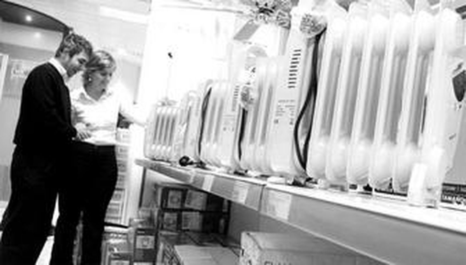 Una pareja busca un aparato de calefacción en una tienda de electrodomésticos.